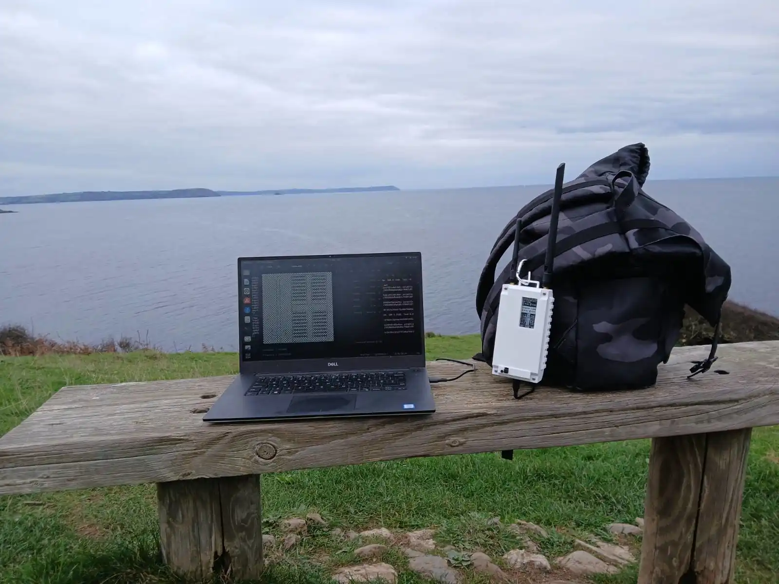 A laptop and radio sat on a bench